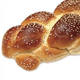 A photo shows a loaf of braided challah scattered with sesame seeds.