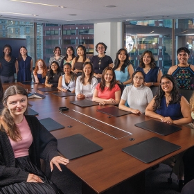 A photo shows the Wellesley in Washingtin interns around a conference room table