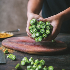 Hands hold a bunch of fresh okra