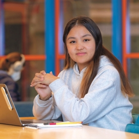 A photo shows Tenzin Yangchen ’25 sitting with her laptop.