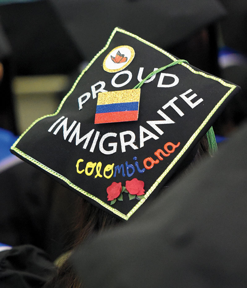 A student wears a hat that says "Proud Immigrante"