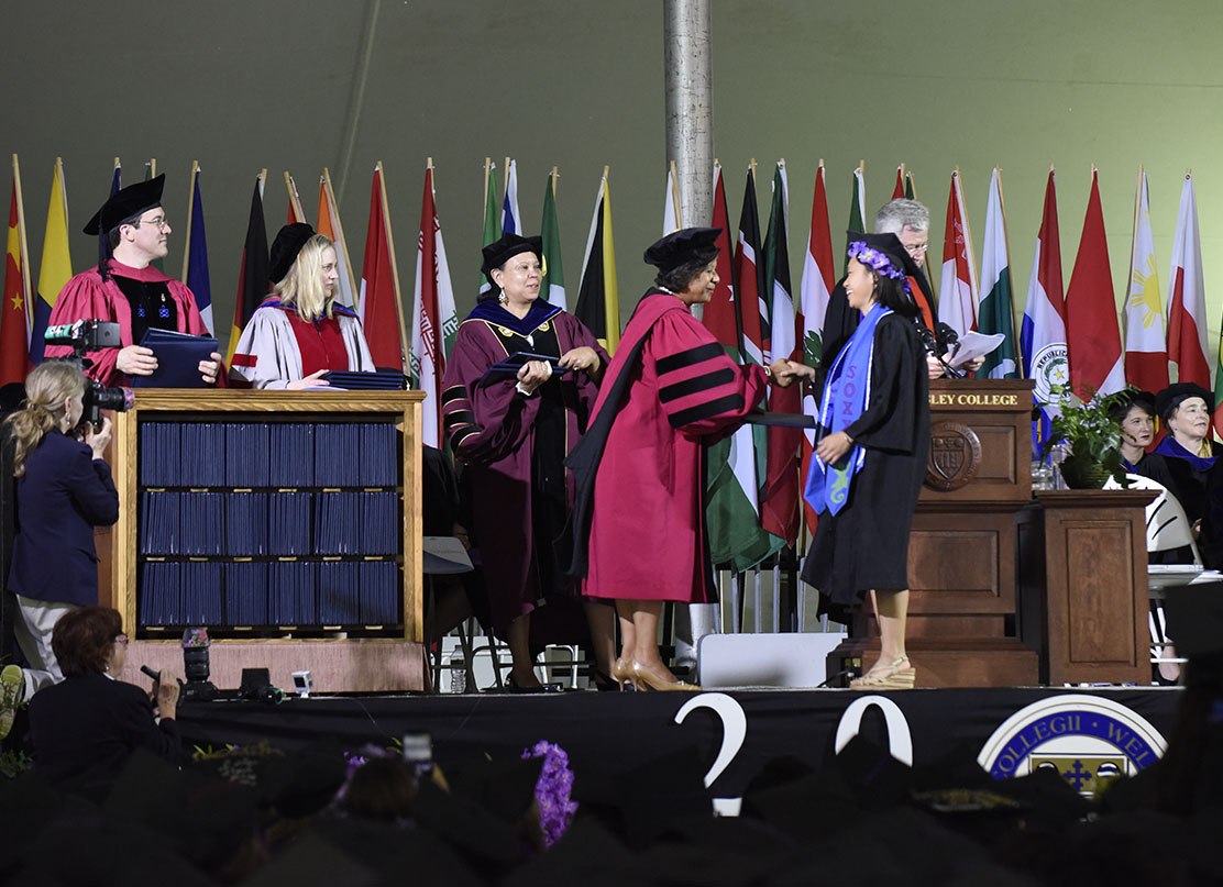 A photo of President Paula Johnson handing a diploma to a member of the class of 2018.