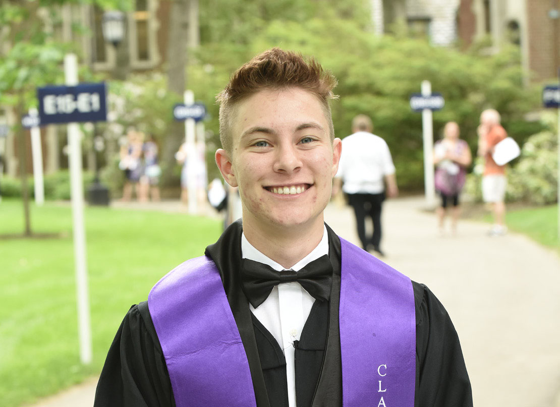 A photo of a graduate draped in a purple stole.
