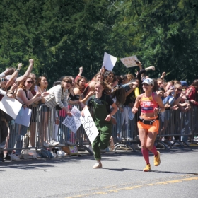 Ella Warburg ’22  is shown running alongside their mother, Shannon Hogan Warburg, in front of the College during the 2022. Boston Marathon.