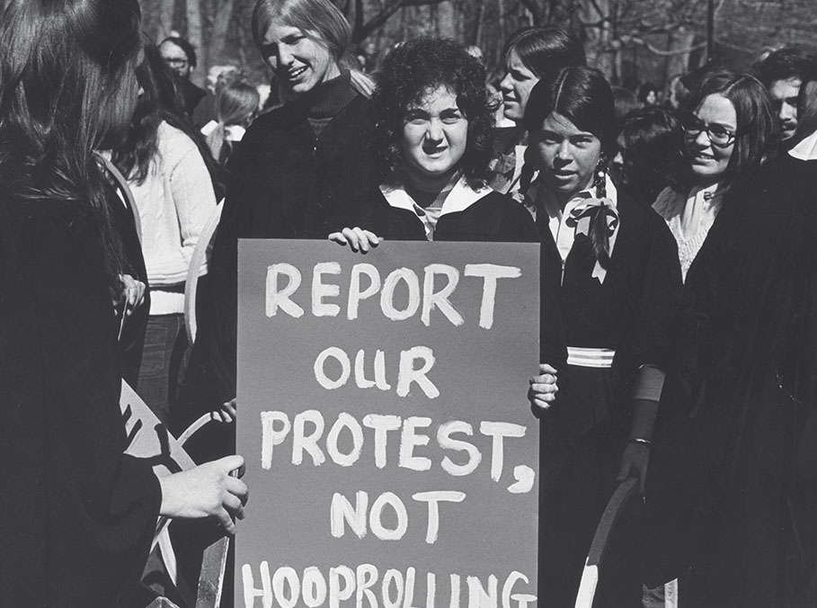 A student holds a sign reading "Report our protest, not Hooprolling" at the 1972 race/