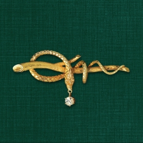 A photo of Secretary Albright's iconic serpent pin -- a snake curled around a branch. A diamond hangs from its mouth.