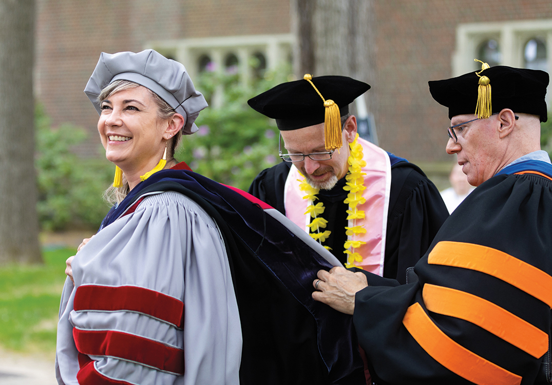 Faculty members adjust their stoles before the procession.