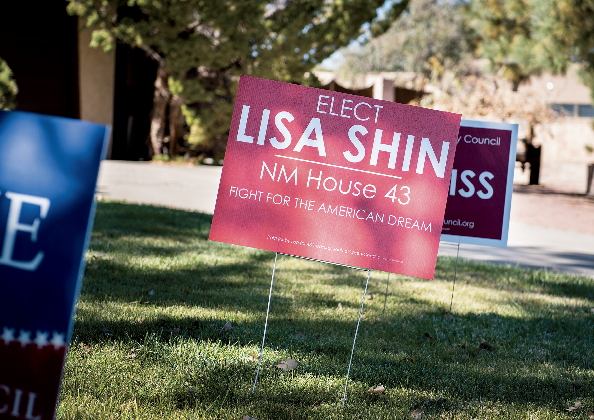 A red lawn sign reads, "Elect Lisa Shin NM House 43 Fight for the American Dream"