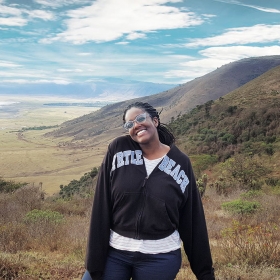 Thanda Newkirk ’21 stands with the Tanzanian mountain landscape behind her