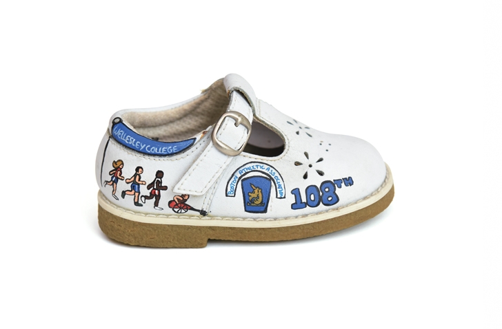 Baby shoe pained with illustrations about the Boston Marathon