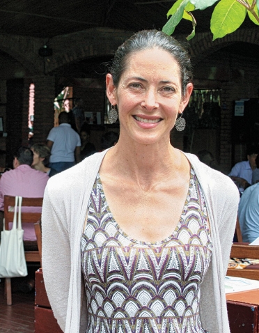 A photo portrait of Alissa Carlat Ruxin '97shows her standing in front of her restaurant, Heaven.