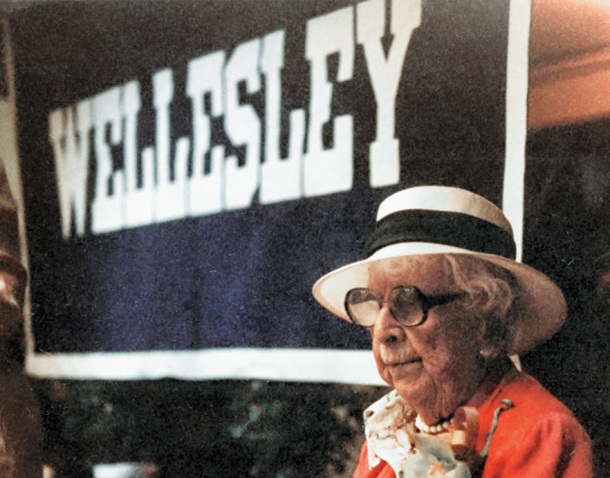 Marjorie Stoneman Douglas 2012, wearing her signature white hat, stands in front of a Wellesley banner.