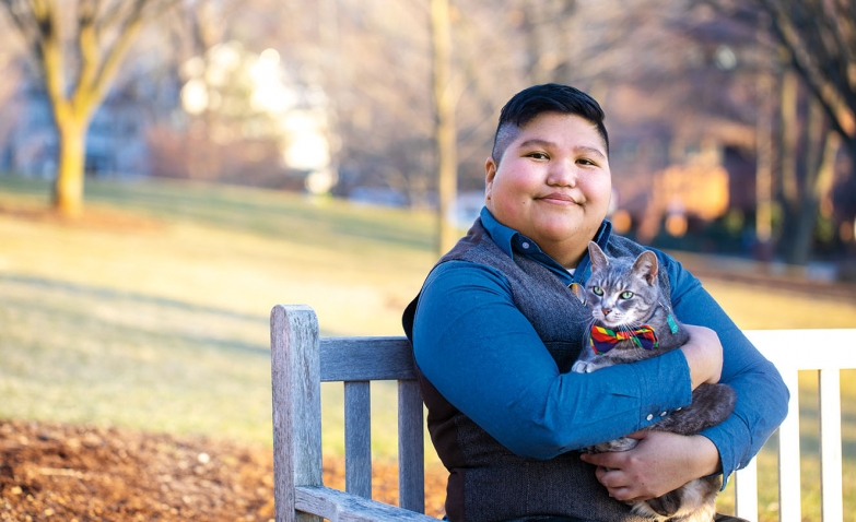 A portrait of AJ Guerrero, Wellesley’s coordinator for LGBTQ+ programs and services, holding her cat