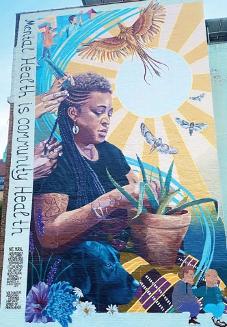 A multi-story mural on the side of a building in New York City depicts Shani Evans '96 having her hair braided.