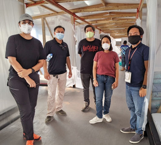 Architect Denise Villar de Castro ’98 and her collaborators stand in an emergency quarantine facility they created outside the Taguig Pateros District Hospital.