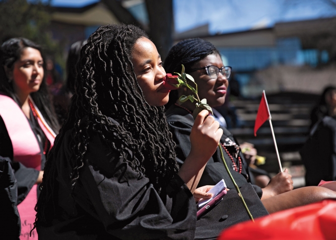 A student holds a rose to her face at the student-organized graduation ceremony in March.