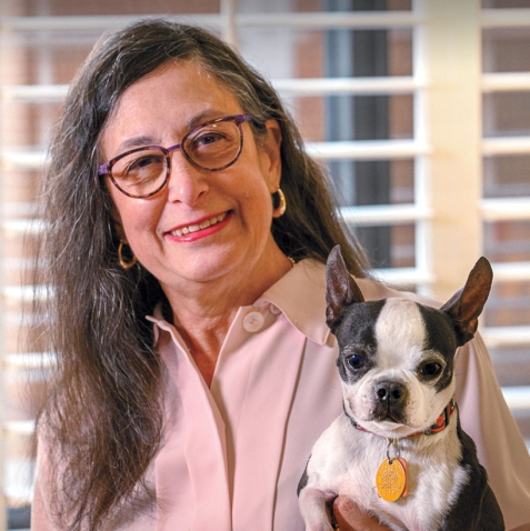 A portrait of Judy Rousuck '72 holding a small dog