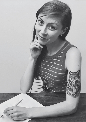 A black-and-white photo of author reveals her upper-arm tattoo of a fox holding a pen. 