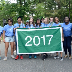 Reunion student workers in the class of 2017 close out the parade with their green banner