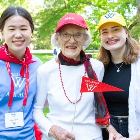 Three alums pose before the reunion parade, one in the class of 1948, one a student, and one a young alum