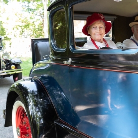An alum in the class of 1948 rides in an antique car