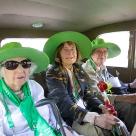 Three alums in the class of 1953 ride in an antique car