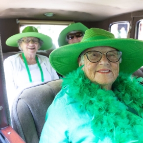 Alums in the class of 1953 ride in an antique car