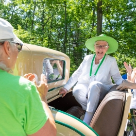 An alum in the class of 1953 rides in an antique car