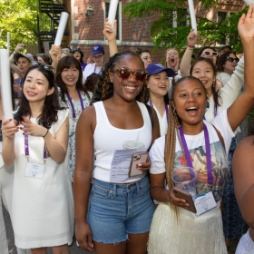 Alums in a purple class cheer during the parade
