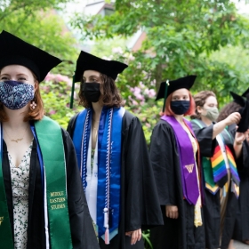 Students in line before commencement, wearing robes and stoles and tams