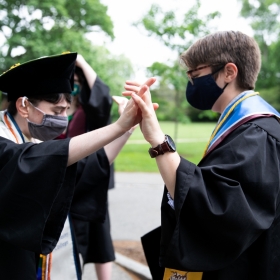 Students clasp hands at commencement