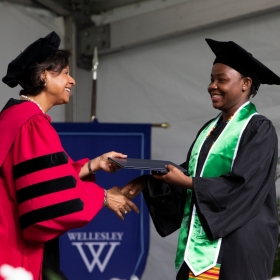 Paula Johnson hands a diploma to a graduate
