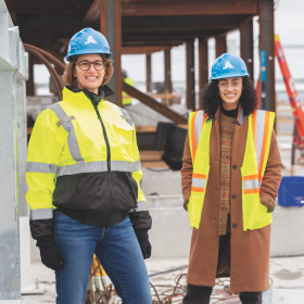 Jahanara “Jana” Freedman ’20 and  Samantha Hand Fratus ’89 stand at a construction site for a 1,000-room hotel project in the Boston seaport district.