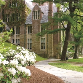 A photo of Founders Hall and a white rhodendron. 