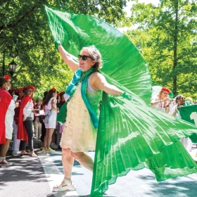 A member of the class of '77 poses wearing a dramatic green cape