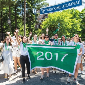 The green class of 2017 cheers behind their banner
