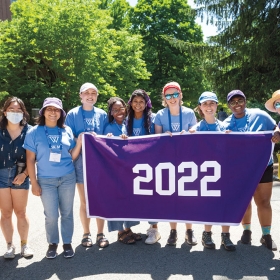 Reunion student workers in the class of 2022 pose behind their purple banner