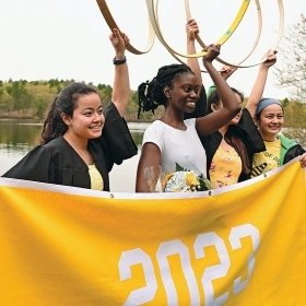 A photo shows Zaria Bunn ’23, winner of Hooprolling 2023, and her friends raising their hoops after the race.