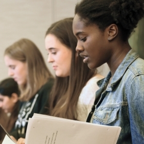 A photo shows five student actors reading student playwrights' work.