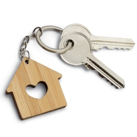 A photo of a keyring with a wooden house with a heart carved in its center, and two keys.