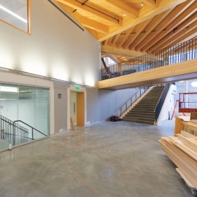 A photo shows an under-construction hallway in the Science Complex, with open wood beams and a walkway above.