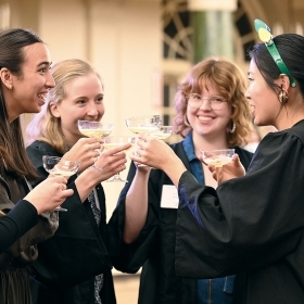 A photo of December finishers toasting each other with champagne.